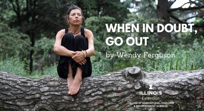 woman sitting on a fallen tree stump reflecting